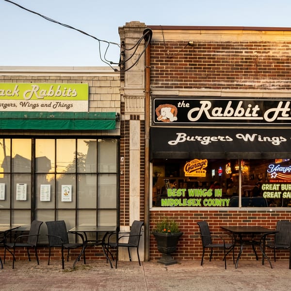 The storefronts of Jack Rabbits and The Rabbit Hole Tavern, with outdoor seating and awnings.
